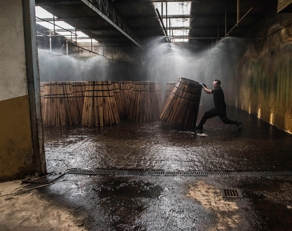 Man rolling barrels in cooperage in Jerez