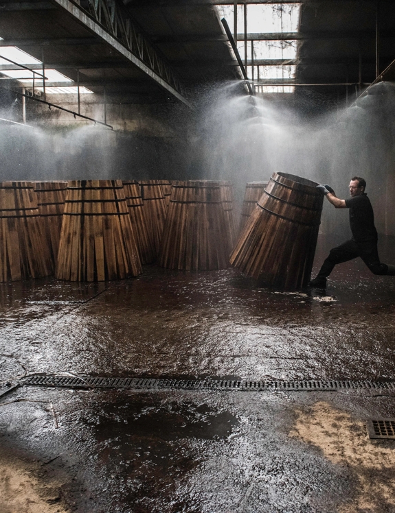 Man rolling barrels in cooperage in Jerez