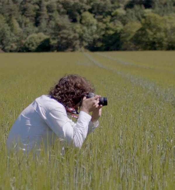 Erik Madigan Heck in field taking photo