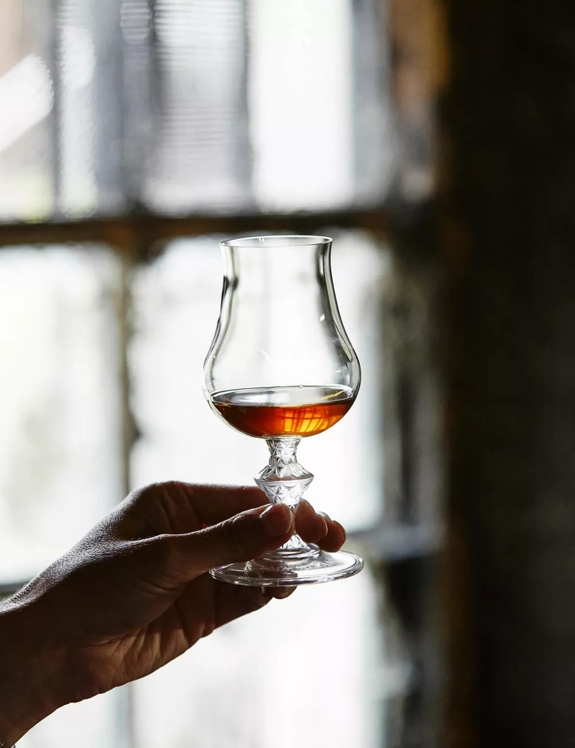 hand holding glass whisky dram