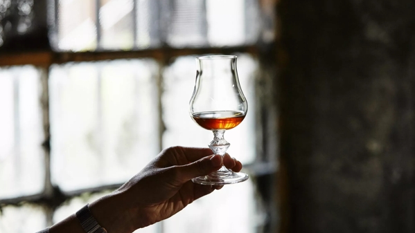 hand holding glass whisky dram
