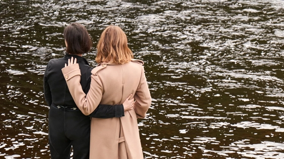 stella and mary mccartney standing facing the river spey