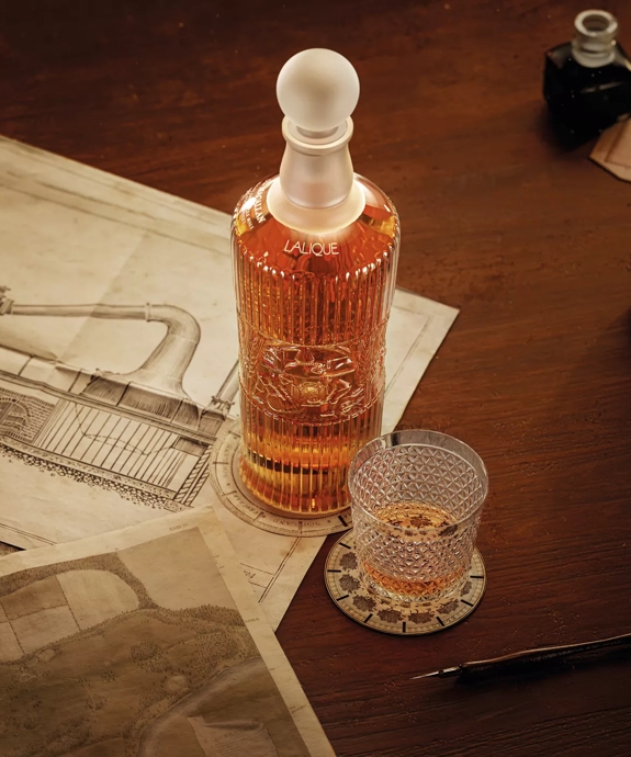 tales of the macallan bottle and glass on table with still drawing