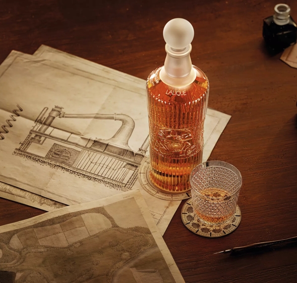 tales of the macallan bottle and glass on table with still drawing