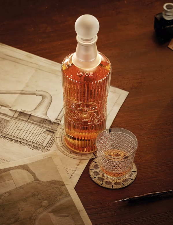 tales of the macallan bottle and glass on table with still drawing