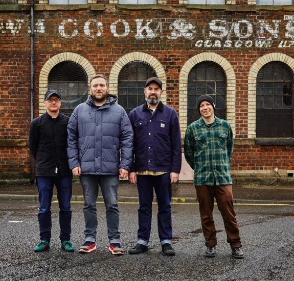 group of men musicians standing outside building
