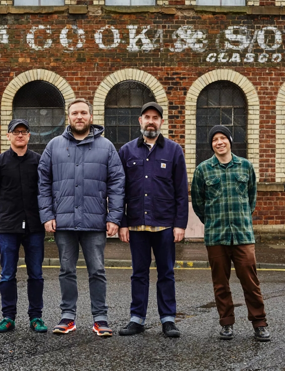 group of men musicians standing outside building