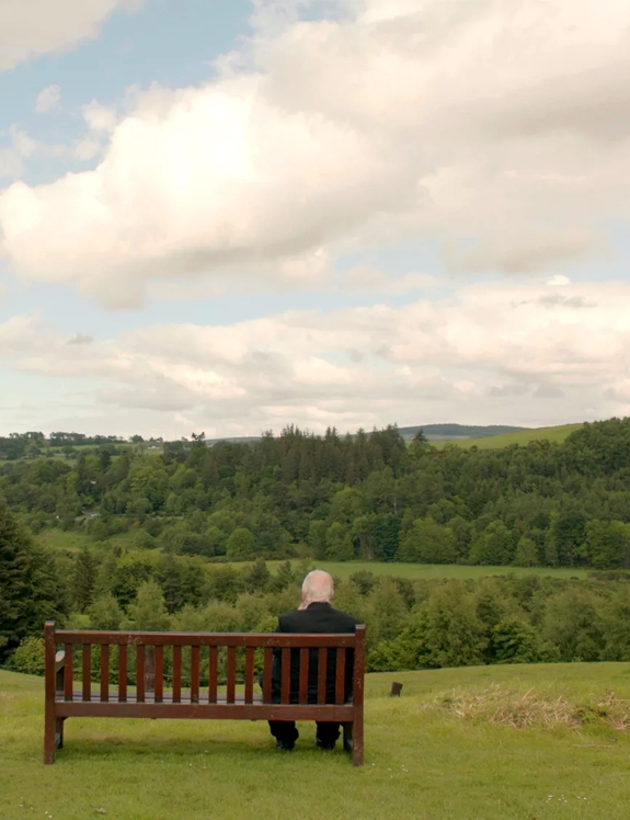 Sir Peter Blake sitting on bench