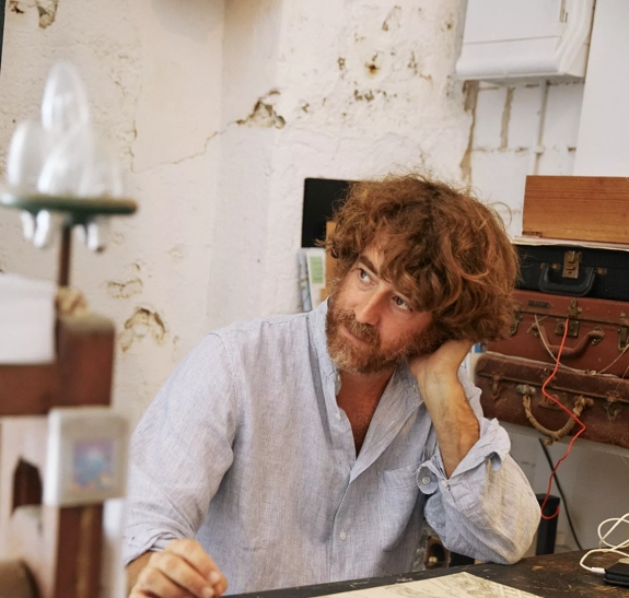 Javi Aznarez sitting at desk with tools