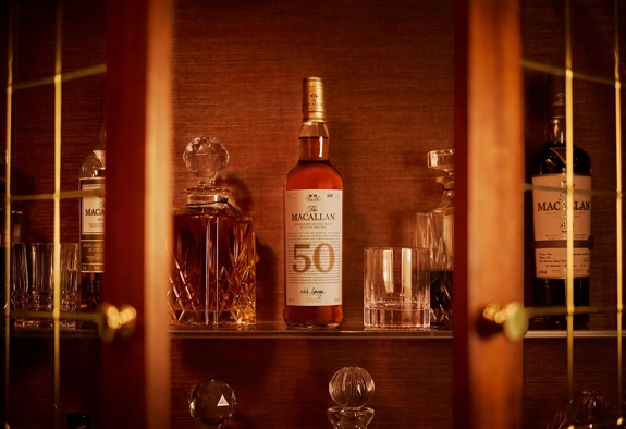 the macallan 50 years old 2018 release whisky bottle sitting on bar shelf with glasses
