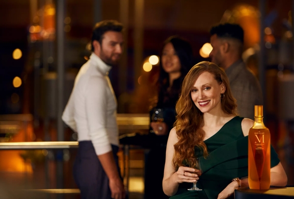 The Macallan M Collection Lifestyle Woman Smiling with Bottle and Dram