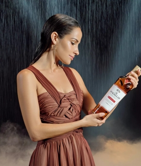 The Macallan Classic Cut 2023 Release Model Looking Down at Classic Cut Bottle with Rain in Background
