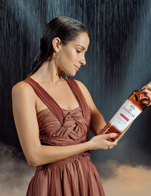 The Macallan Classic Cut 2023 Release Model Looking Down at Classic Cut Bottle with Rain in Background
