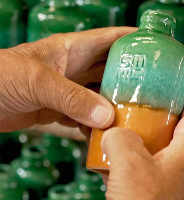 hands holding ceramic jug
