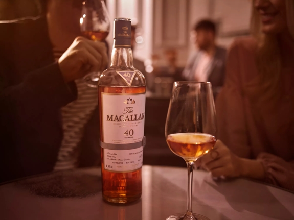 the macallan sherry oak 40 years old 2017 release whisky bottle and glass in social setting