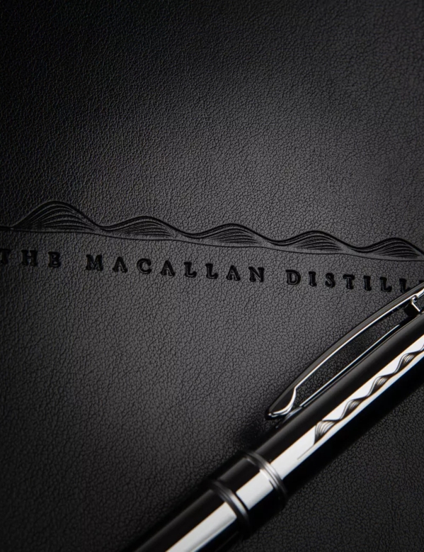 The Macallan Notebook and Pen Close up of The Macallan Logo Printed