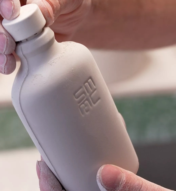 hands holding ceramic jug
