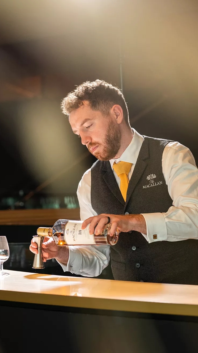 Man pouring drams behind The Macallan Distillery Bar