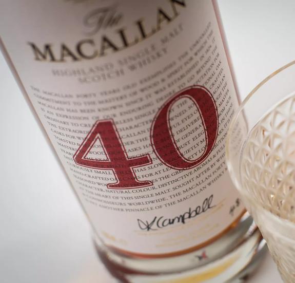 The Macallan Red Collection 40 year old whisky bottle label close up with glass