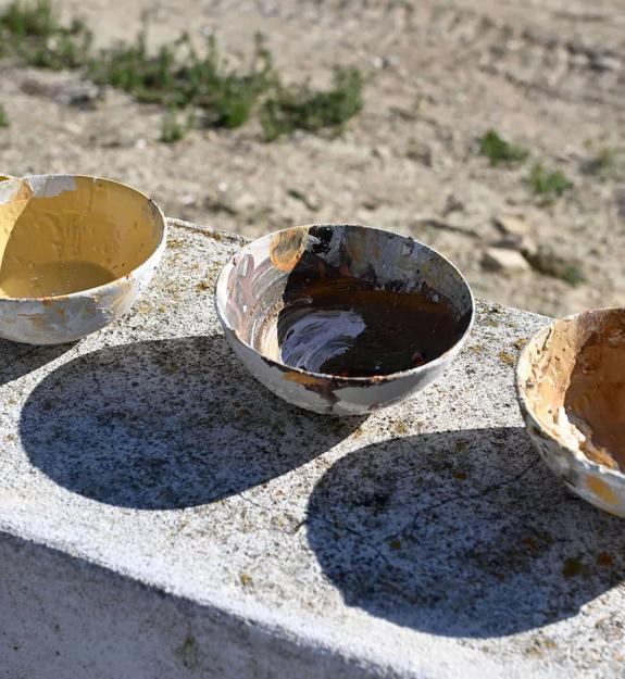artists paint bowls in the sun