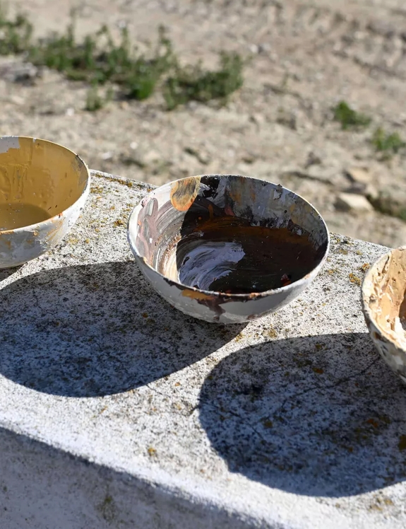 artists paint bowls in the sun