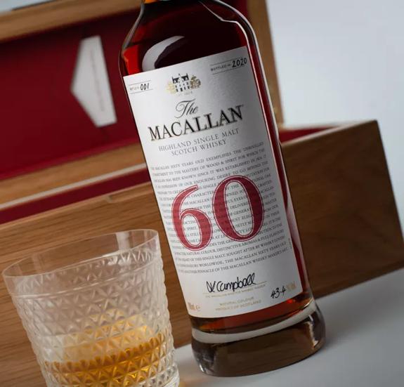 The Macallan 60 year old whisky bottle and glass in front of open box